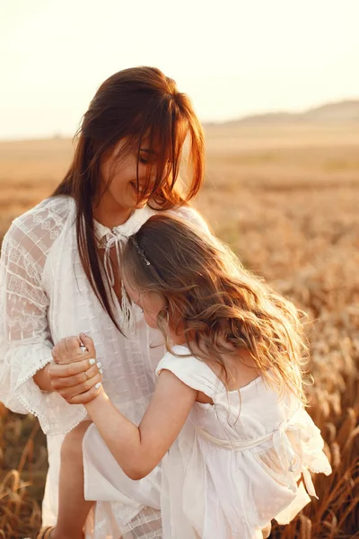 Family in a summer field. Sensual photo. Cute little girl. Woman in a white dress.