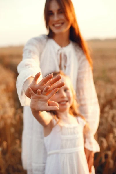 Family in a summer field. Sensual photo. Cute little girl. Woman in a white dress.