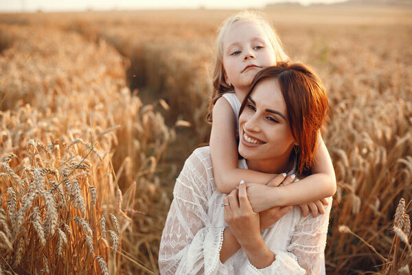 Family in a summer field. Sensual photo. Cute little girl. Woman in a white dress.