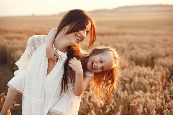 Family in a summer field. Sensual photo. Cute little girl. Woman in a white dress.