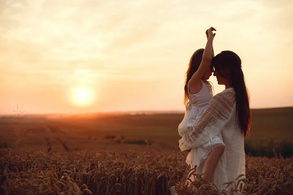 Family in a summer field. Sensual photo. Cute little girl. Woman in a white dress.