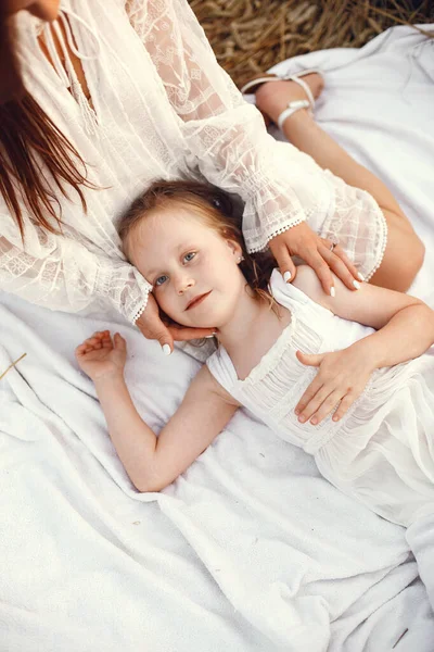 Family in a summer field. Sensual photo. Cute little girl. Woman in a white dress.