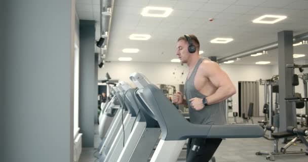 Side View Young Athlete Gray Shirt Headphones Treadmill Modern Bright — Vídeo de Stock