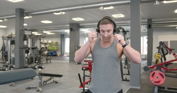 Young Athlete Gray Shirt Headphones Turns Timer Fitness Bracelet — 图库视频影像
