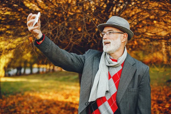Красивый Дедушка Осеннем Парке Старик Серой Куртке Шляпе Мужчина Телефоном — стоковое фото