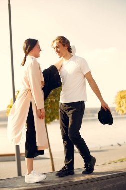 Deniz kenarında bir çift. Siyah şapkalı adam. Günbatımı arka planında eşleşin.