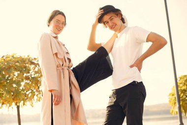 Deniz kenarında bir çift. Siyah şapkalı adam. Günbatımı arka planında eşleşin.