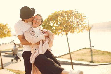 Deniz kenarında bir çift. Siyah şapkalı adam. Günbatımı arka planında eşleşin.