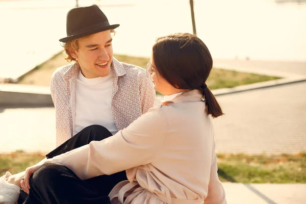 Deniz kenarında bir çift. Siyah şapkalı adam. Günbatımı arka planında eşleşin.