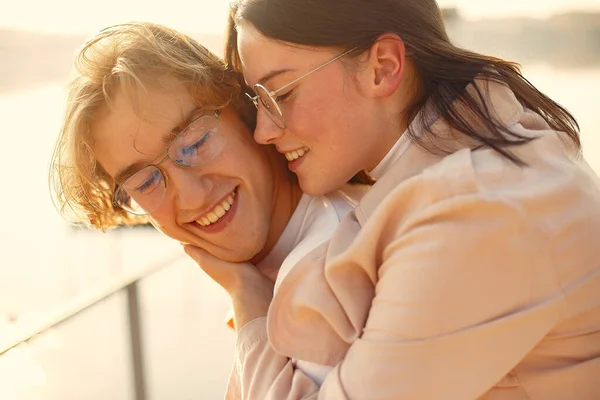 Couple by the water. Guy in a white t-shirt. Pair on a sunset background.