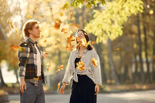 Couple in a park. Guy in a white t-shirt. Golden autumn.