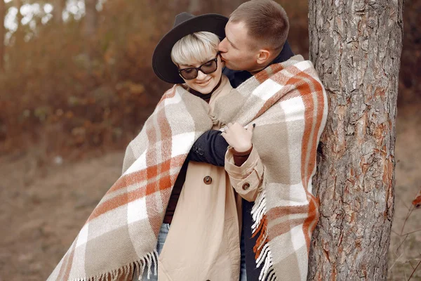 Couple in a field. Girl in a brown coat. Man with his wife in a autumn forest