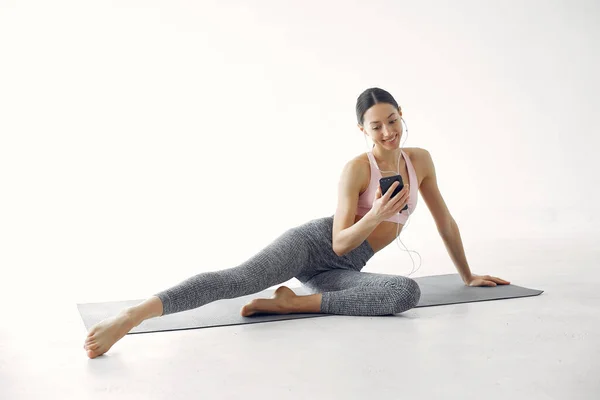 Beautiful girl in yoga studio. A woman doing a yoga. Lady in a pink top.