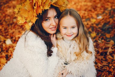 Güzel bir anne ve kızı. Sonbahar parkında bir aile. Altın sonbahar