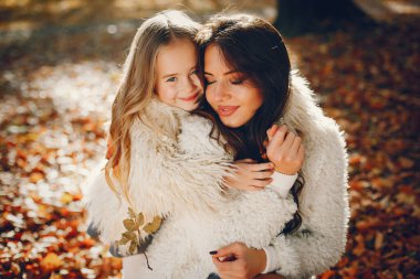 Güzel bir anne ve kızı. Sonbahar parkında bir aile. Altın sonbahar