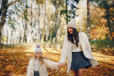 Güzel bir anne ve kızı. Sonbahar parkında bir aile. Altın sonbahar