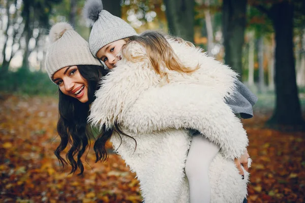 Beautiful mother with daughter. Family in a autumn park. Golden autumn