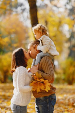 Küçük tatlı kızı olan bir aile. Kahverengi kazaklı baba. Sonbahar tarlasında bir aile