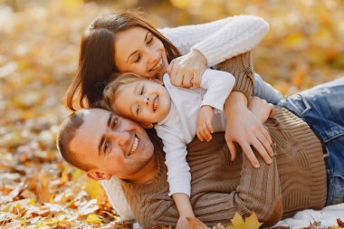 Küçük tatlı kızı olan bir aile. Kahverengi kazaklı baba. Sonbahar tarlasında bir aile