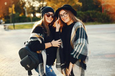 Güneşli yaz şehrinde yürüyen iki şık genç kız