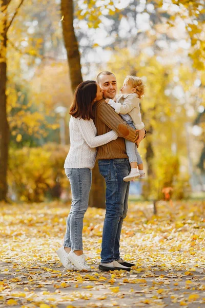 Küçük tatlı kızı olan bir aile. Kahverengi kazaklı baba. Sonbahar tarlasında bir aile