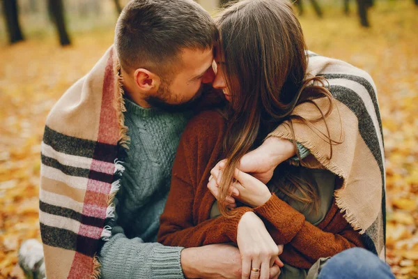 Couple in a park. Woman in a brown sweater. Man with a beard