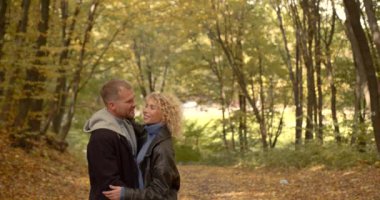 Young happy couple hugging in autumn park. Family leisure
