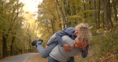 A young man holds his wife on his back. The wife hugs her husband