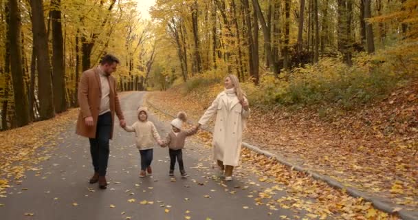 Νεανική Κομψή Οικογένεια Δύο Παιδιά Περπατά Στο Πάρκο Φθινόπωρο Χαρούμενη — Αρχείο Βίντεο