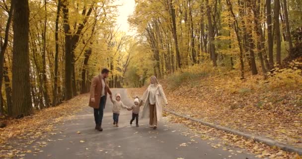 Νεανική Κομψή Οικογένεια Δύο Παιδιά Περπατά Στο Πάρκο Φθινόπωρο Χαρούμενη — Αρχείο Βίντεο