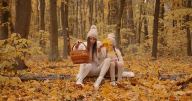 Mom and her daughter spending weekend, picnic in the autumn forest together. Mother and child relations.
