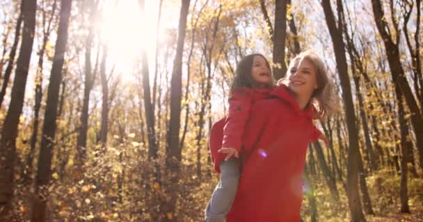 Young Blond Mother Holding Her Daughter Her Back Walk Autumn — Stok Video