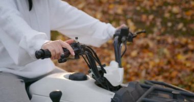 Close up of a girl in white rides an ATV. The concept of active recreation and off-road driving
