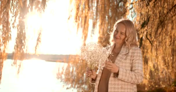 Вагітна Блондинка Тримає Руках Букет Білих Квітів Березі Ставка Осінній — стокове відео