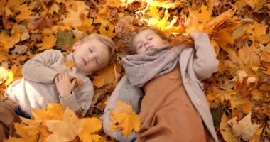 Cute little brother and sister playing on the weekend. Spending time in nature. Two schoolkids in a fall forest.