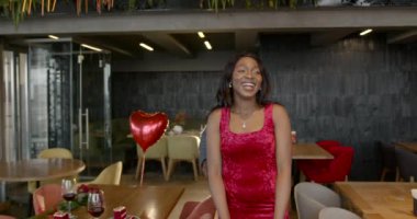 Kırmızı gülleri olan aşık bir adam restorandaki randevusuna güzel bir buket getiriyor. Kadın şaşırdı ve gülümsüyor. Çiçekler, romantik ilişki ve flört konsepti.