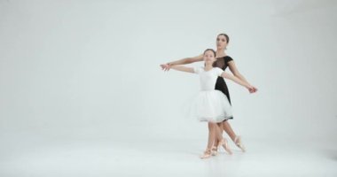 Genç öğretmenle gösteri yapan bir kız. Dans, bale konsepti. Beyaz stüdyo.