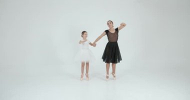 Genç öğretmenle gösteri yapan bir kız. Dans, bale konsepti. Beyaz stüdyo.