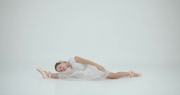 穿着白色燕尾服的女孩伸展在白色工作室里 交际舞学校的概念 — 图库视频影像