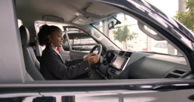 İçinde otururken modern arabanın içini inceleyen siyah kadın. Kadın araba galerisinde yeni araba seçiyor..