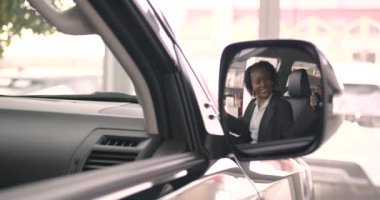 İçinde otururken modern arabanın içini inceleyen siyah kadın. Kadın araba galerisinde yeni araba seçiyor..