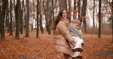 Sonbahar orman manzarası. Mutlu çocuk ve anne hafta sonu eğleniyor. Okul, hafta sonu, doğa konsepti..