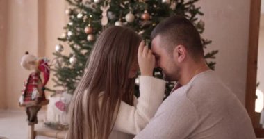 Noel ağacının yanında genç bir aile öpüşüyor. Güzel bir kız ve erkek arkadaşı Noel süveteri örüyorlar. Yeni yılda romantik bir randevuları var..