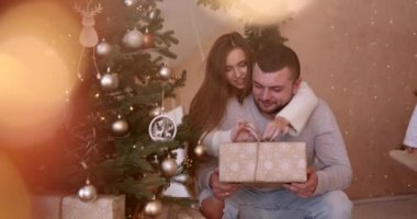 Noel ağacının yanında bir çift. Romantik çift, evin içinde süslü Noel ağacının yanında sarılıyorlar. Tatillerin tadını çıkarıyorum..