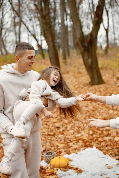 Cropped photo of a little girl with her father. Man and her little girl playing in autumn forest and laughing. Brunette man throwing her daughter in the air.