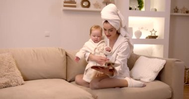 Anne ve bebek bornozlu çocuk. Mutlu gülümseyen aile cilt bakımı.