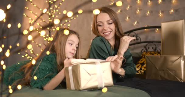 クリスマスの装飾部屋 小さな女の子は彼女の母親と一緒に時間を費やして 抱きかかえ 贈り物をアン梱包し 毛皮の木を飾る 美しいお母さんとスタイリッシュな娘 冬の休暇のコンセプト 正月とクリスマス — ストック動画