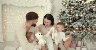 Neşeli genç ebeveynler ve sevimli küçük oğullar Noel 'i kutluyor ve eğleniyorlar. Aile tatilleri. Çocukluk kavramı.