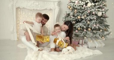 Neşeli genç ebeveynler ve sevimli küçük oğullar Noel 'i kutluyor ve eğleniyorlar. Aile tatilleri. Çocukluk kavramı.