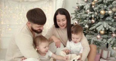 Neşeli genç ebeveynler ve sevimli küçük oğullar Noel 'i kutluyor ve eğleniyorlar. Aile tatilleri. Çocukluk kavramı.